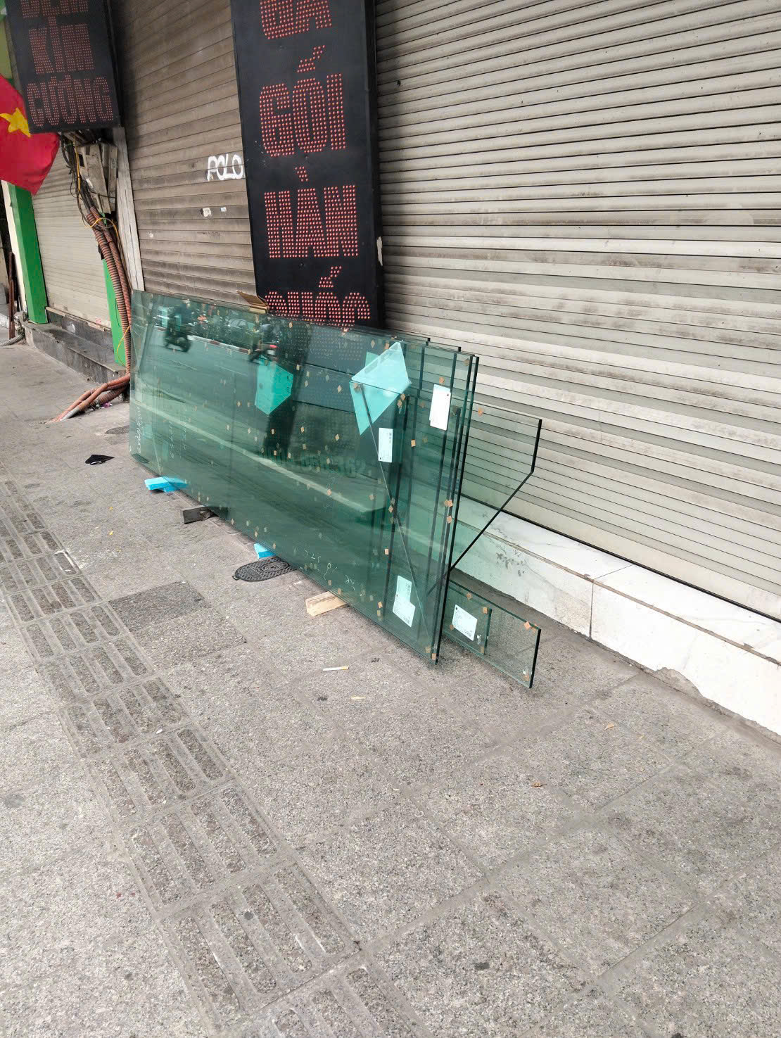 Các tấm kính được kê gọn gàng trước cửa hàng để chờ giao